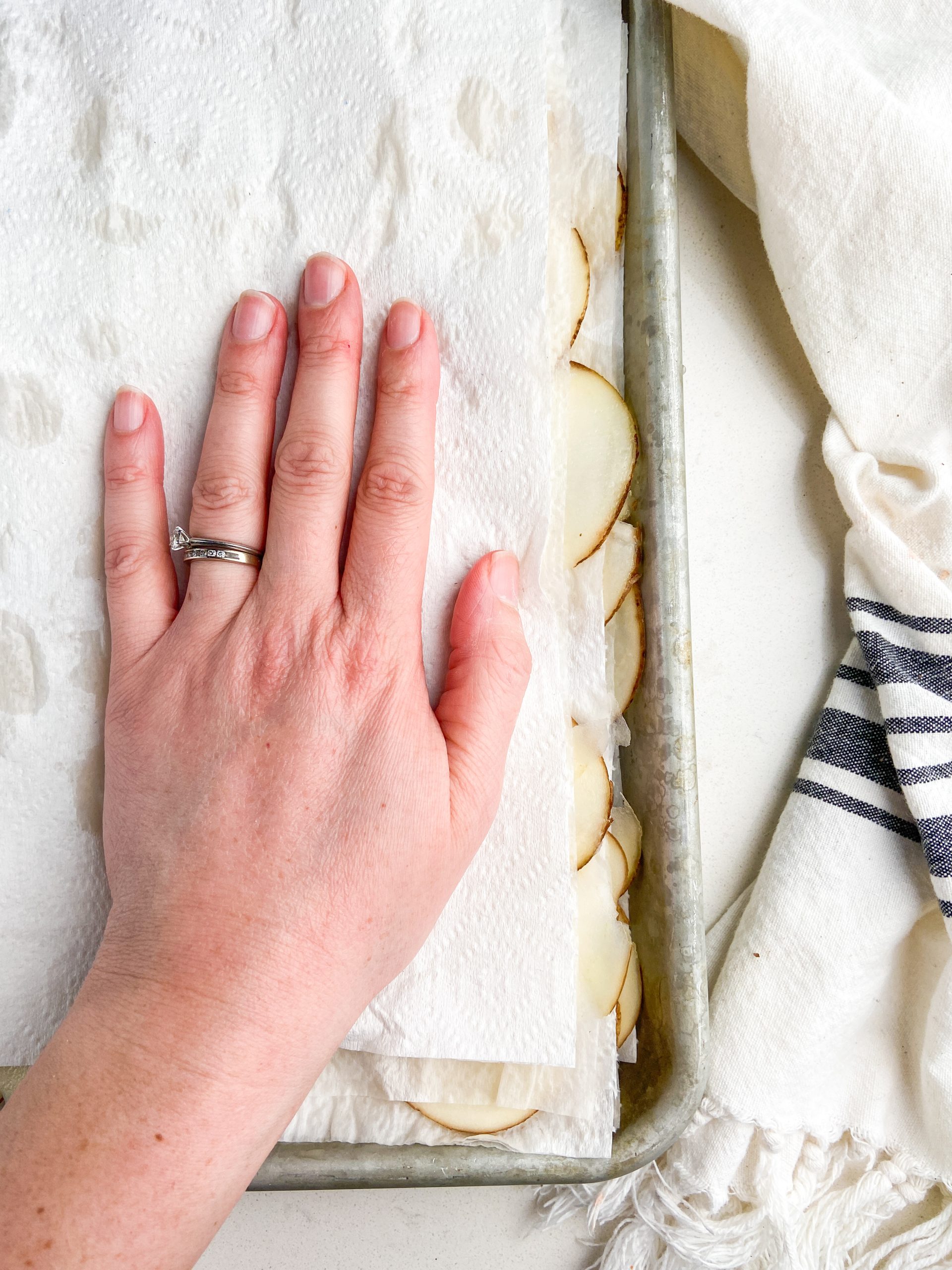 Drying potato slices on paper towels.
